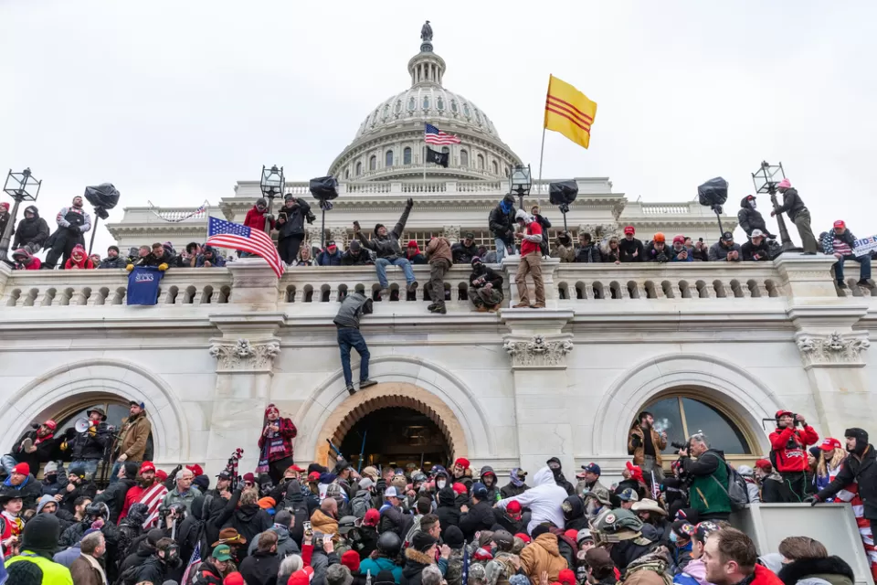Trump supporting insurrectionists scale the walls of the U.S. Capitol Building on January 6, 2021.